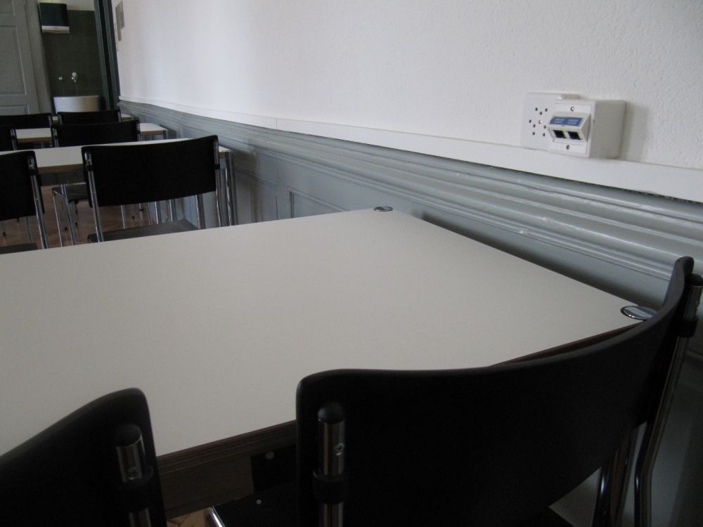 Seminarraum KAB-E-05: Stromanschlüsse hat es mit Blick Richtung Wandtafel zweimal rechts an der Wand sowie auf der linken Seite hinter den Sitzreihen, ebenfalls an der Wand.