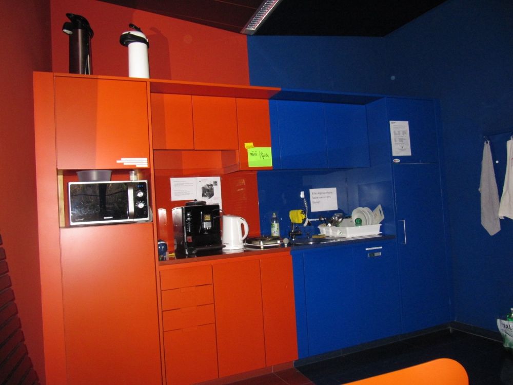 Aufenthaltsraum KAA-D-11: Küchenkombination mit Kaffeemaschine, Kühlschrank, Mikrowelle, aufklappbare kleine Herdplatte, Lavabo sowie einem kleinen Selbstbedienungskiosk.