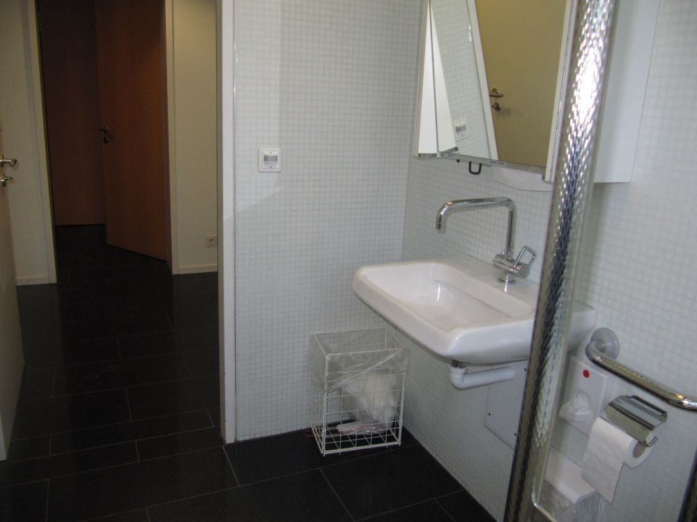 Rollstuhl-WC KAA-E-02A: Lavabo mit verstellbarem Spiegel und den zwei Eingangstüren.