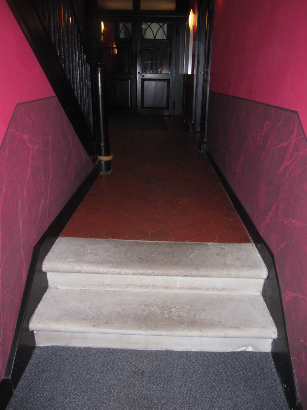 KAA, Stockwerk D: Zwei Stufen ohne Handlauf auf dem Stockwerk E. Sie befinden sich vor der relativ steilen Treppe, welche hinunter zum Stockwerk D führt.