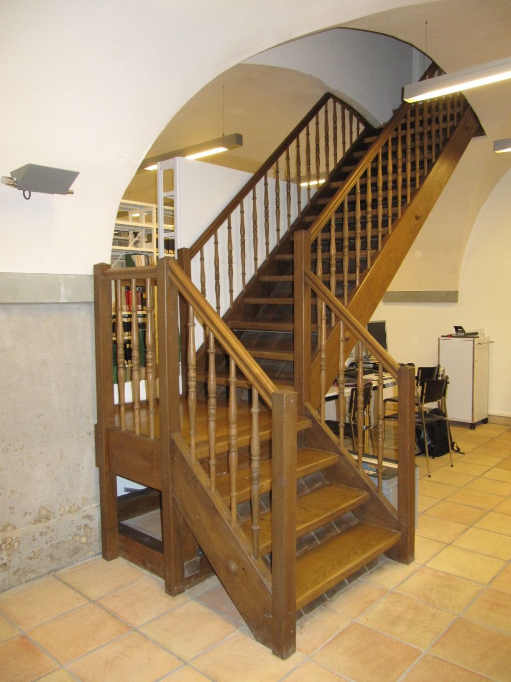 KAA-D, Bibliothek: Relativ steile Treppe mit Handlauf, um in die Bibliothek zu gelangen.