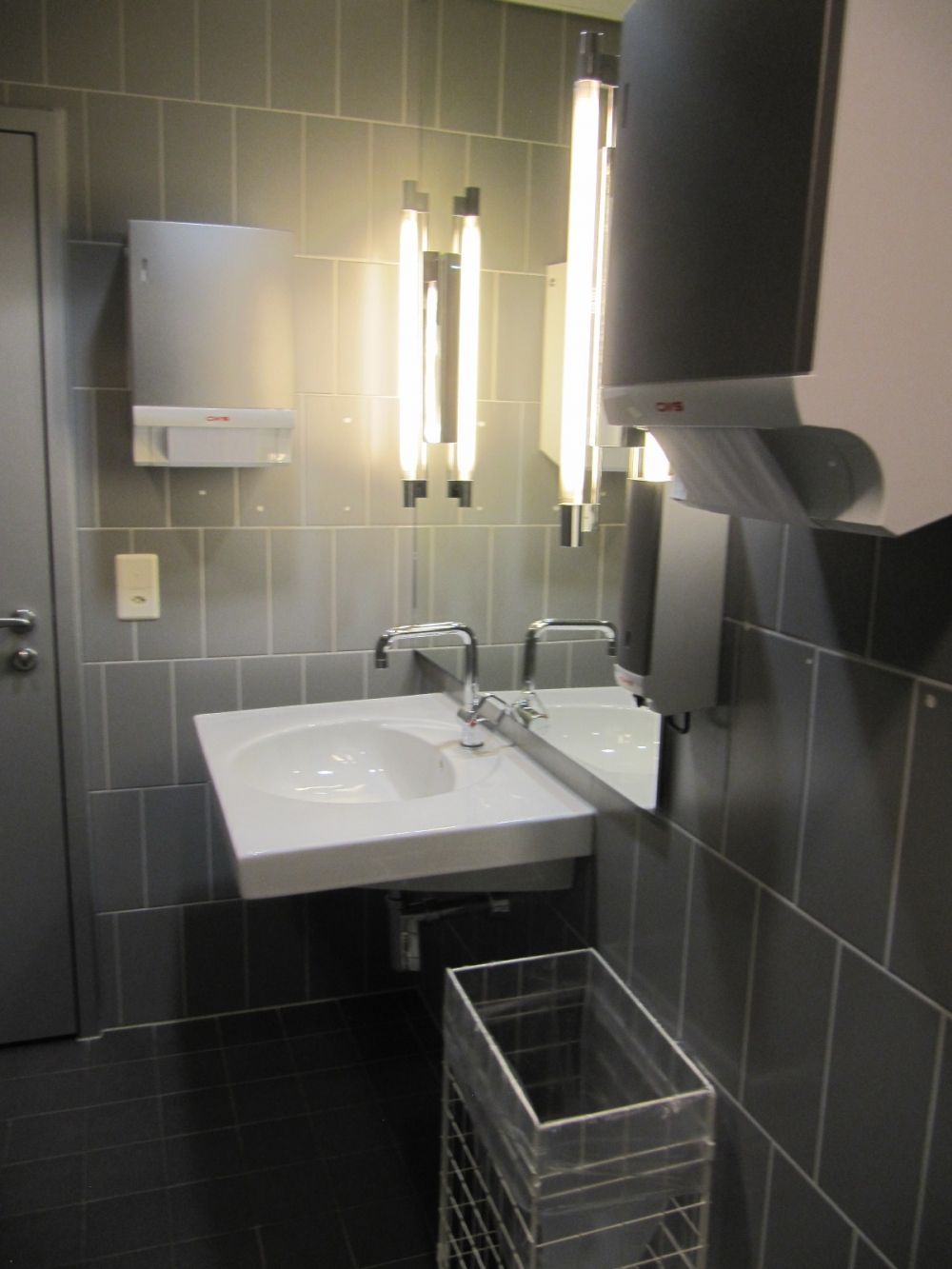 WC-Anlage AND-4-47: gut beleuchtetes Lavabo mit Spiegel.