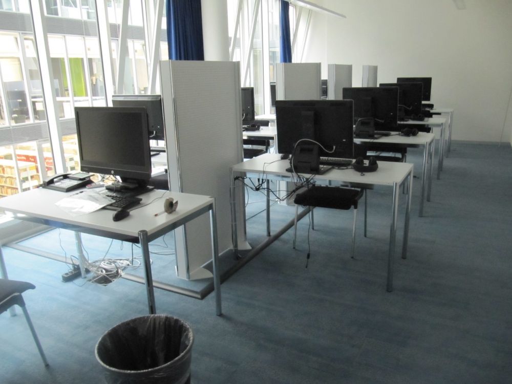 Praktikumsraum AND-4-77: Praktikumsraum mit acht Schulungscomputern mit Trennwand dazwischen sowie einem Telefon beim vorderen Computer.
