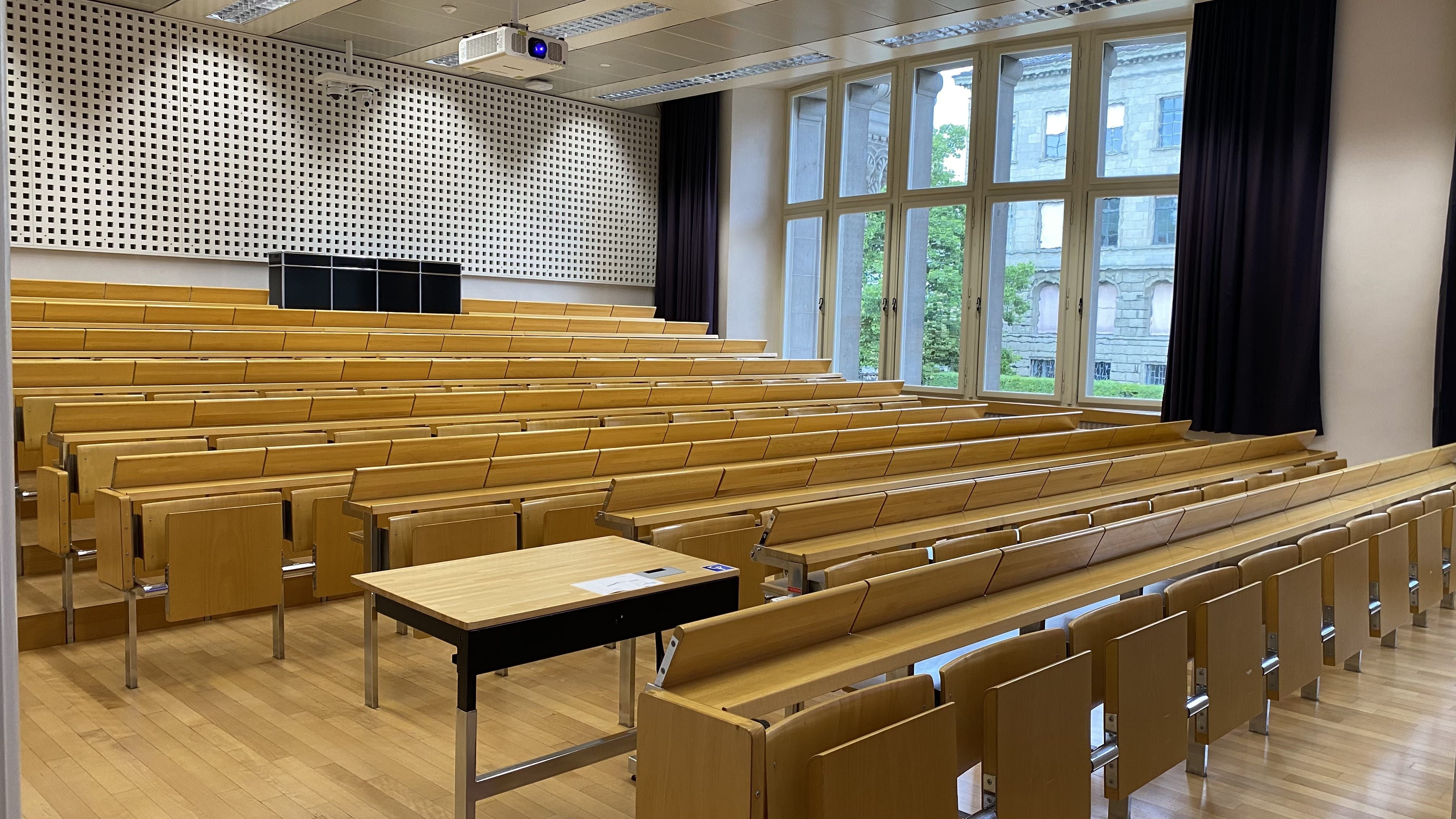Hörsaal KO2-F-150: Ansicht auf den Raum von der Eingangstüre aus. Der Hörsaal besitzt zwei Eingangstüren, beide sind gleich gross und befinden sich auf derselben Raumseite.