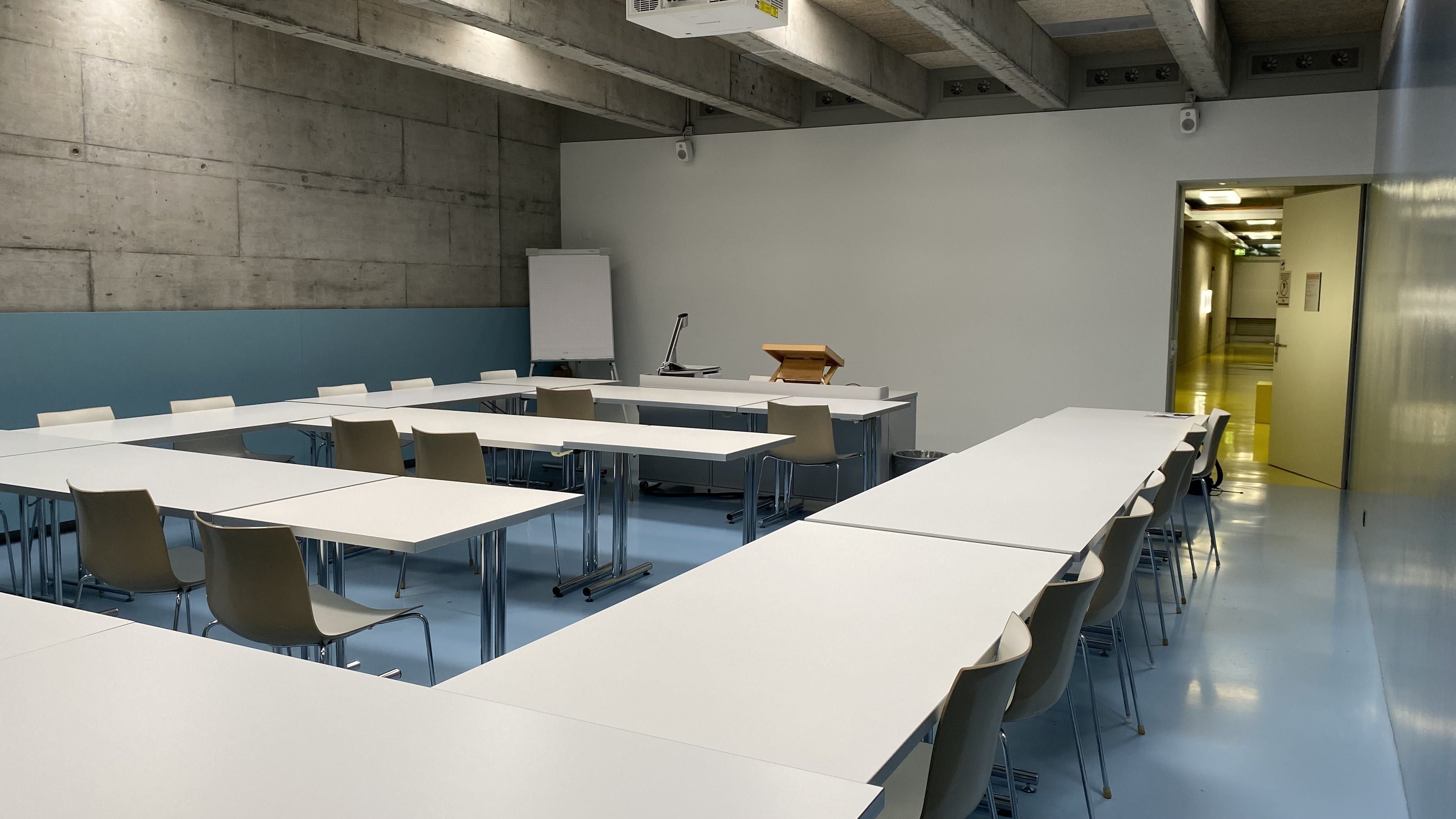 Seminarraum FRE-D-15: Ansicht auf den Raum zur Eingangstüre hin. Die Türe befindet sich rechts im Bild.