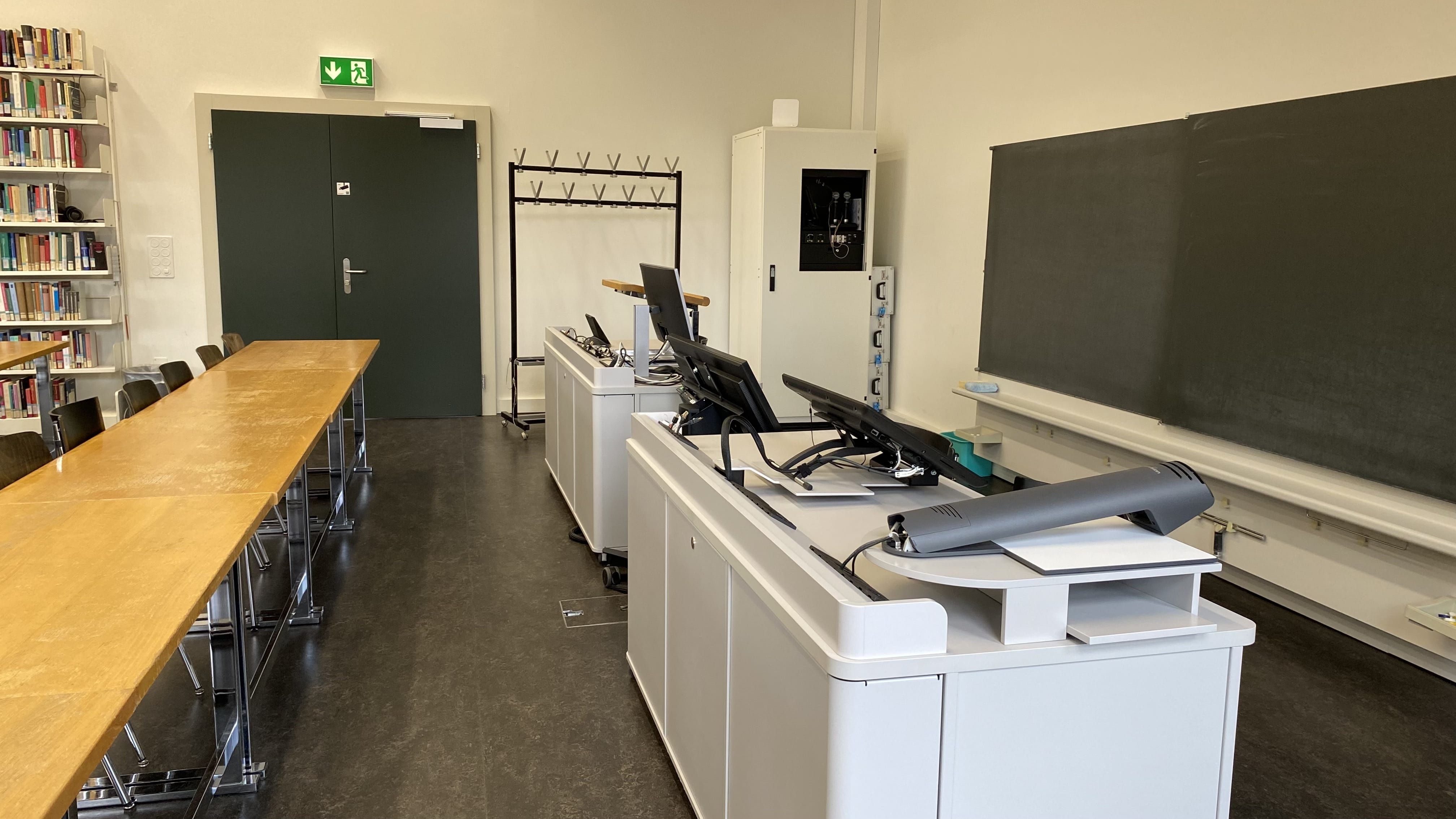 Seminarraum KIR-2-200: Ansicht auf die Eingangstüre nahe am Dozierendenpult.