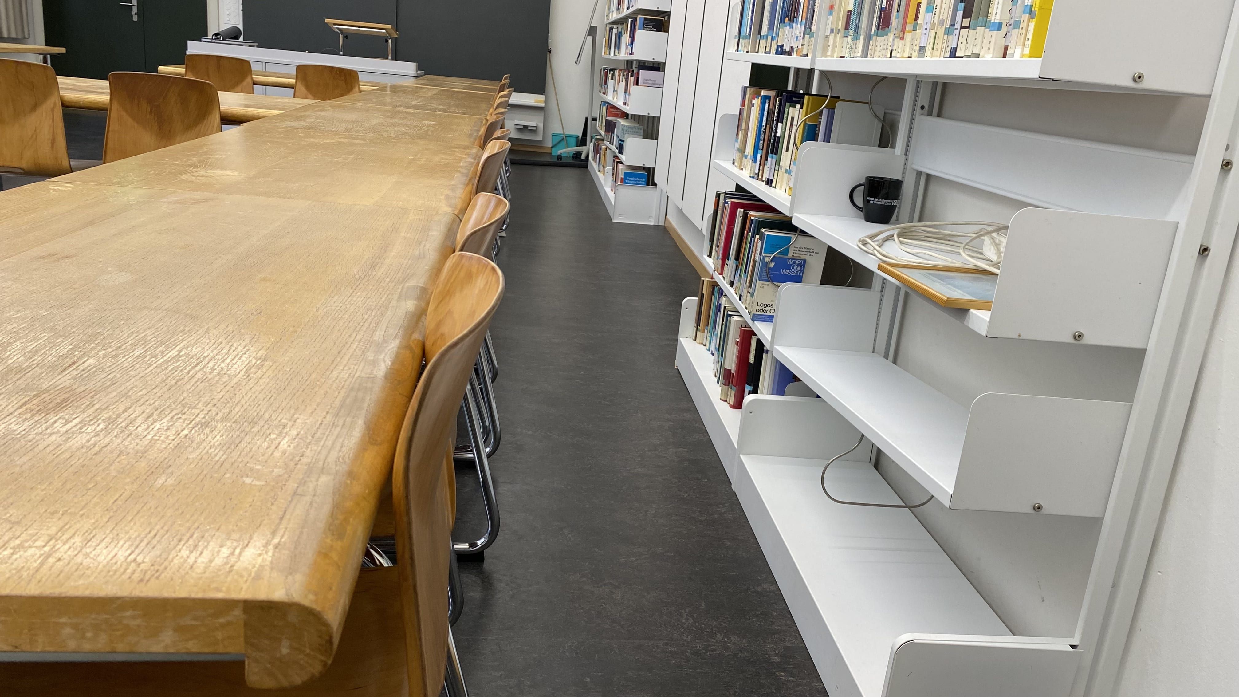 Seminarraum KIR-201: Der rechte Durchgang auf Seite des Bücherregals ist etwas schmaler.