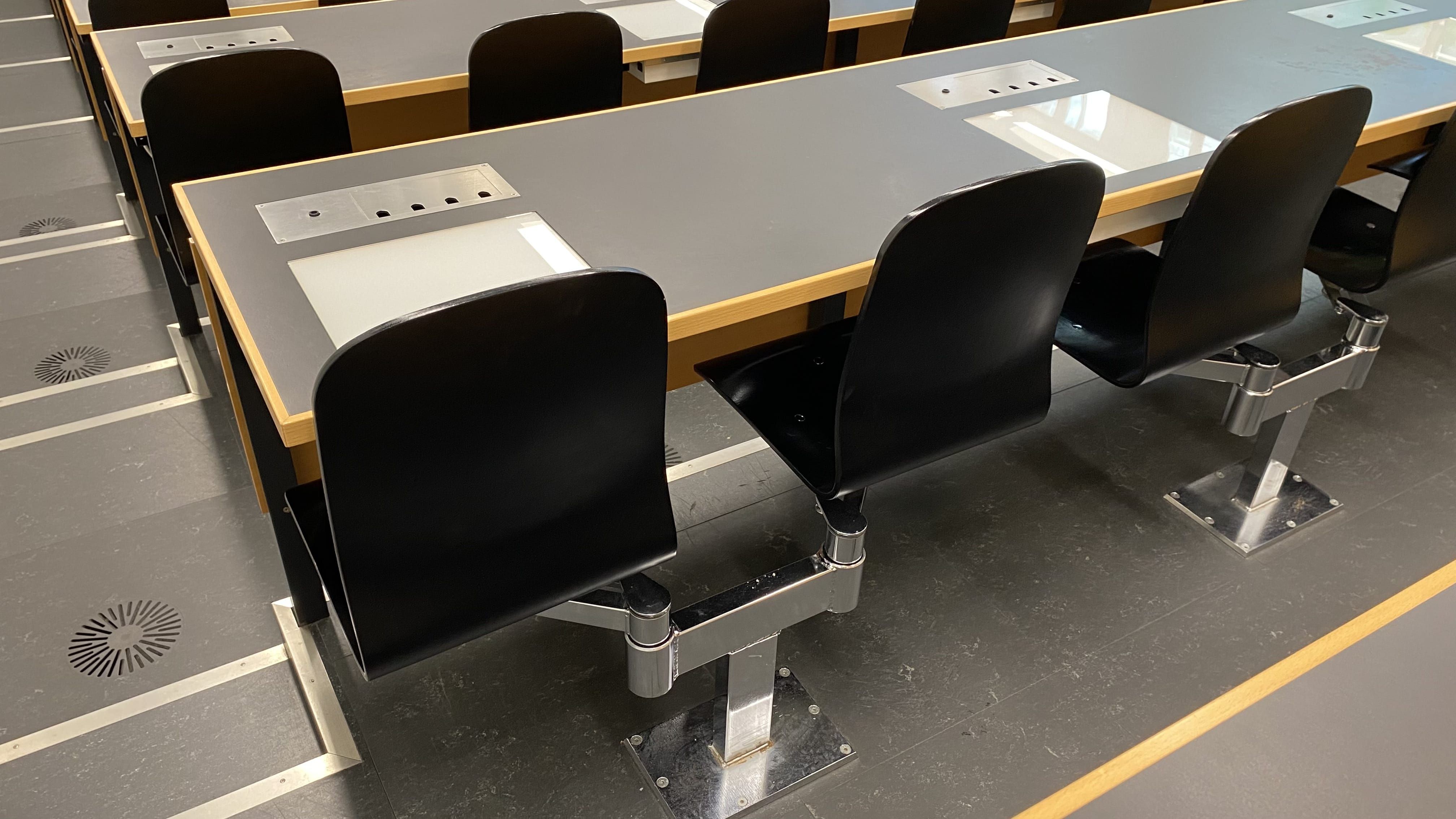 Hörsaal PLF-U1-205: Ansicht auf die fixe Bestuhlung aller Sitzreihen mit Ausnahme der hintersten Reihe.