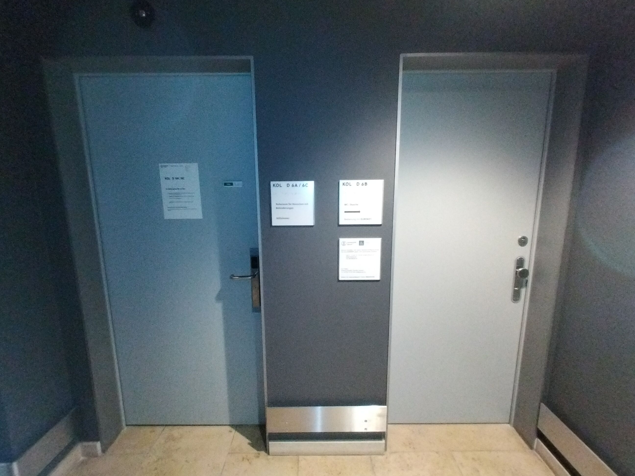 Linke Türe: Eingang zum Ruheraum (KOL-D-6a) und zum Stillzimmer (KOL-D-6c), welches ein separater abschliessbares Zimmer innerhalb des Ruheraums ist. Rechte Türe: Rollstuhl-WC und Dusche (KOL-D-6b).