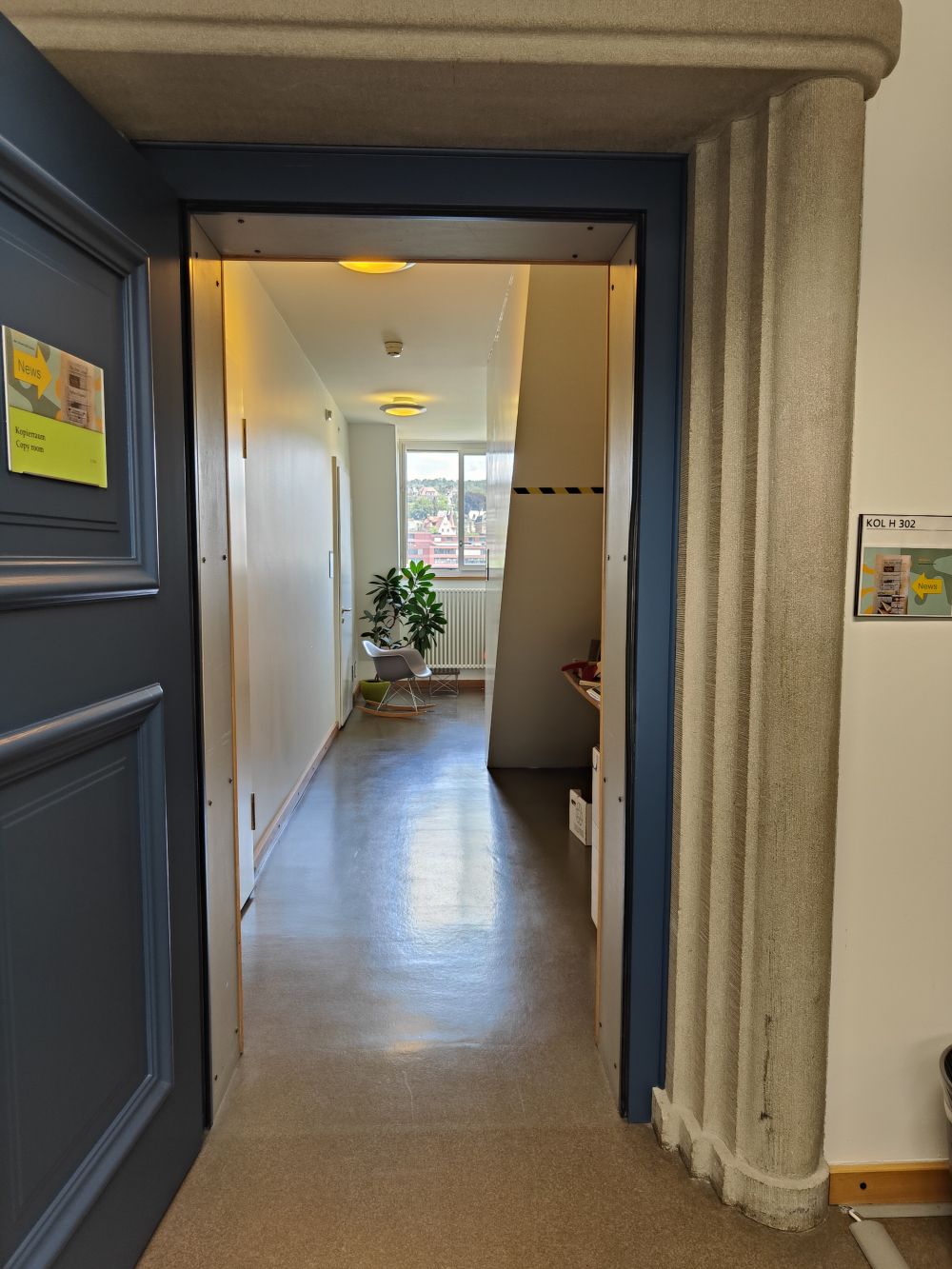 Kopierraum KOL-H-302b: Blick vom Foyer in den Kopierraum. Der Kopierer befindet sich auf der rechten Seite. Hinten im Raum hat es Stuehle und aktuelle Zeitungen. In diesem Bereich der Bibliothek darf gegessen werden.