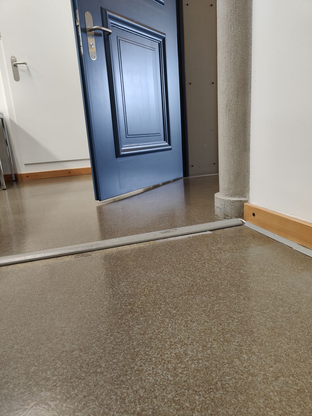 Kopierraum KOL-H-302b: Ca. 2 cm hohe Schwelle vor der Tuer zum Kopierraum. Unter der Schwelle sind Kabel verlegt. Die Schwelle verschiebt sich und ist nicht fixiert.