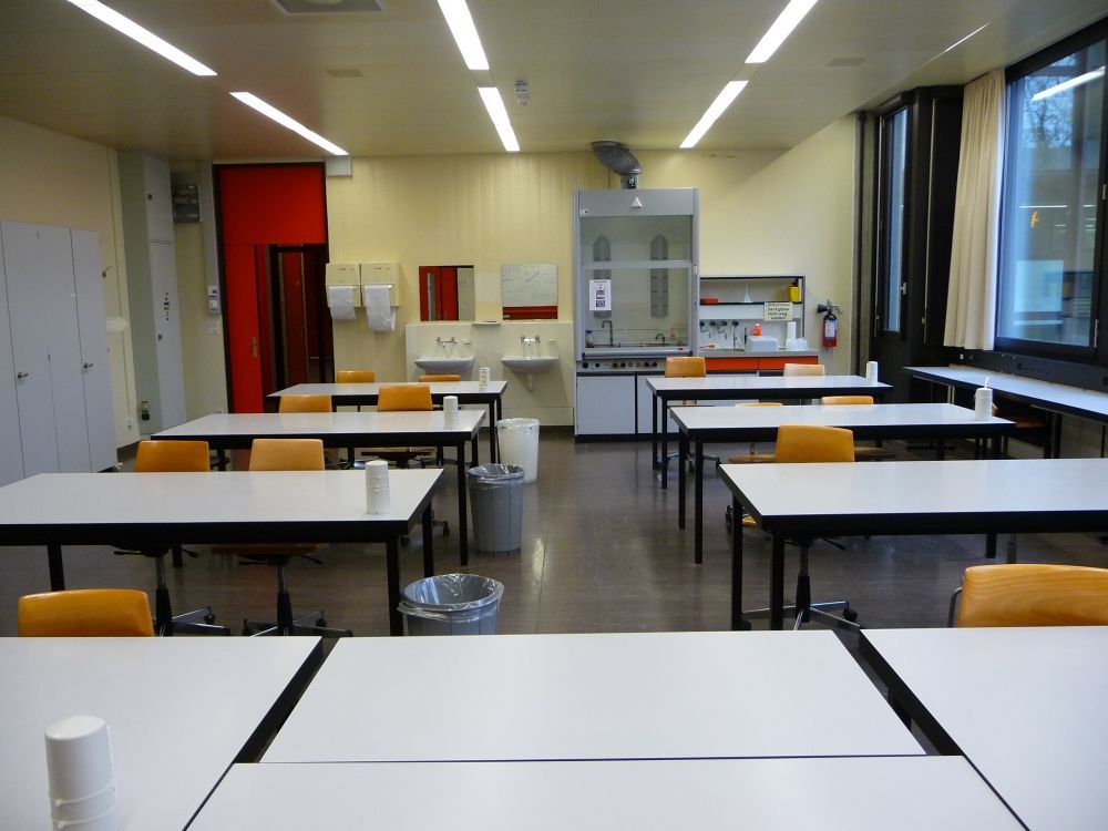 Praktikumsraum Y23-G-22: G-22 von der Tafel aus gesehen. Die Tür hinten links führt zu der Glastür, dem Rollstuhl-WC und dem Doppellift.