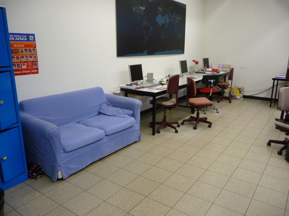 Arbeitsraum für Studierende Y23-G-10: Blaue Couch und drei der sechs Arbeitsplätze mit fest eingerichteten Computern.