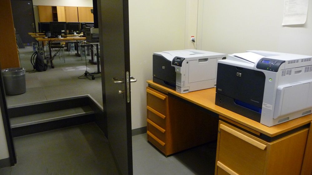 Computer-Arbeitsraum Y36-J-23: Der Zugang über den Computer-Vorraum (J-21), in dem die vier Drucker stehen. Im Bild sind zwei davon zu sehen, und auch hier gibt es nach dem Eingang zwei Treppenstufen.