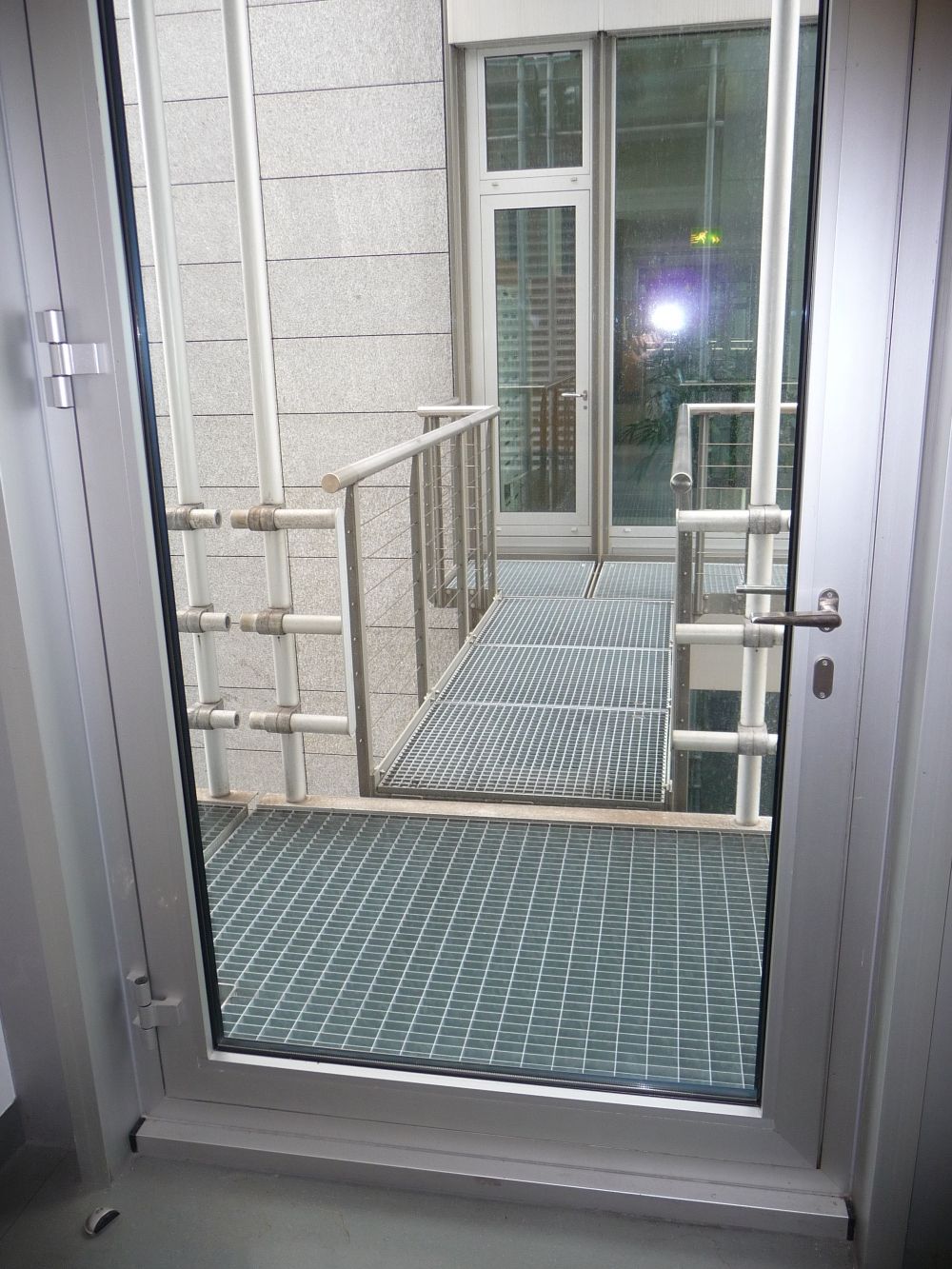 Y36-M, Balkon/Terrasse: Direkter Zugang zum Fluchtbalkon, der sich am Ende des Flurs auf der linken Seite befindet. Das gegenüberliegende Gebäude ist Y55, zu dem ein Übergang besteht.