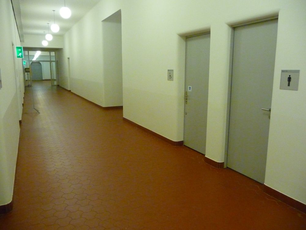 WC-Anlage RAI-E-119: Das Herren-WC befindet sich rechts neben dem Rollstuhl-WC. Geht man nach dem Rollstuhl-WC um die Ecker, findet man das Damen-WC direkt auf der rechten Seite.