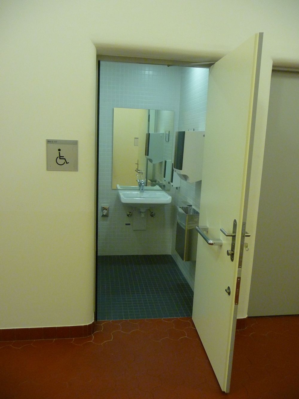 Rollstuhl-WC RAI-E-117: Rollstuhl-WC von aussen. Die Tür lässt sich nur soweit öffnen, wie auf dem Bild zu sehen ist.