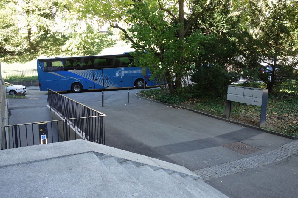 Gebäude RAA: Ansicht vom Haupteingang her auf den Vorplatz. Ganz links im Bild erkennt man die Hebebühne, rechts die Briefkästen, wo der Schalter um die Hebebühne auf die niedrigere Ebene zu holen angebracht ist.