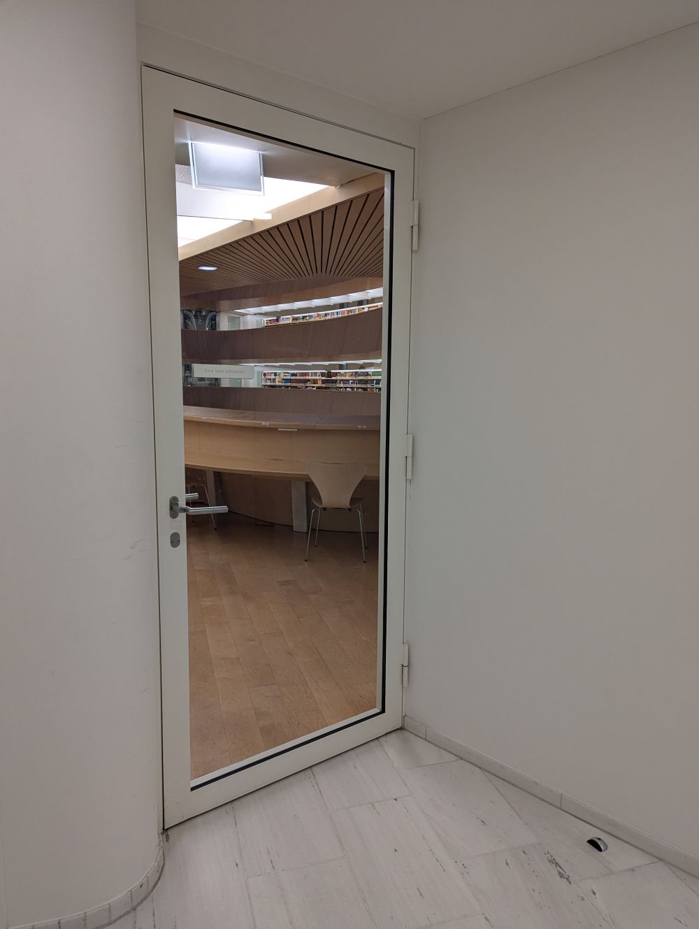 RAI-BIB, Stockwerk F: Glastür zwischen Treppenhaus und Arbeitsplätzen.