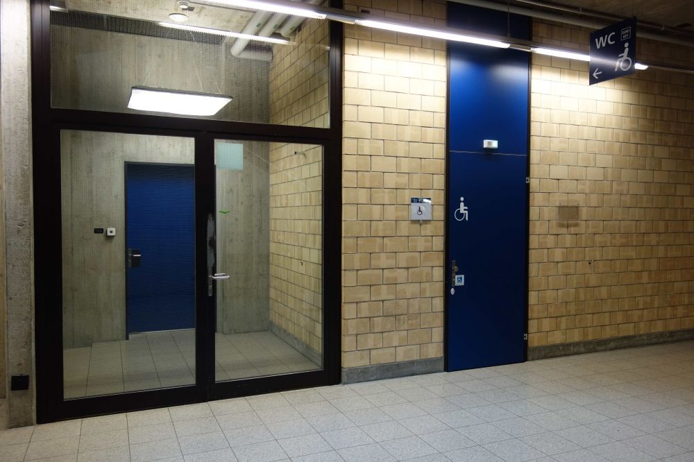 Y21, Stockwerk F: Gerade auf der Rückseite des Lifts des Y21 befindet sich ein Rollstuhl-WC und gerade links von diesem WC führt eine nicht beschilderte Glastüre in ein Treppenhaus hinein und unmittelbar danach eine weitere Türe wieder hinaus. Nach der zweiten Türe führt ein kurzer Gang zum Y02.