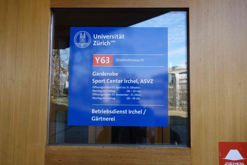 Y63, Stockwerk D: Eingangstüre mit Infos zu den Garderoben.