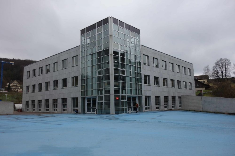 Gebäude Y63: Auf dem blauen Platz vor dem Gebäude Y27 stehend:
                            Links vom Y27 führt der stufenlose Weg hinauf, rechts vom Y27 beginnt
                            der kürzere, jedoch nicht stufenlose Weg.