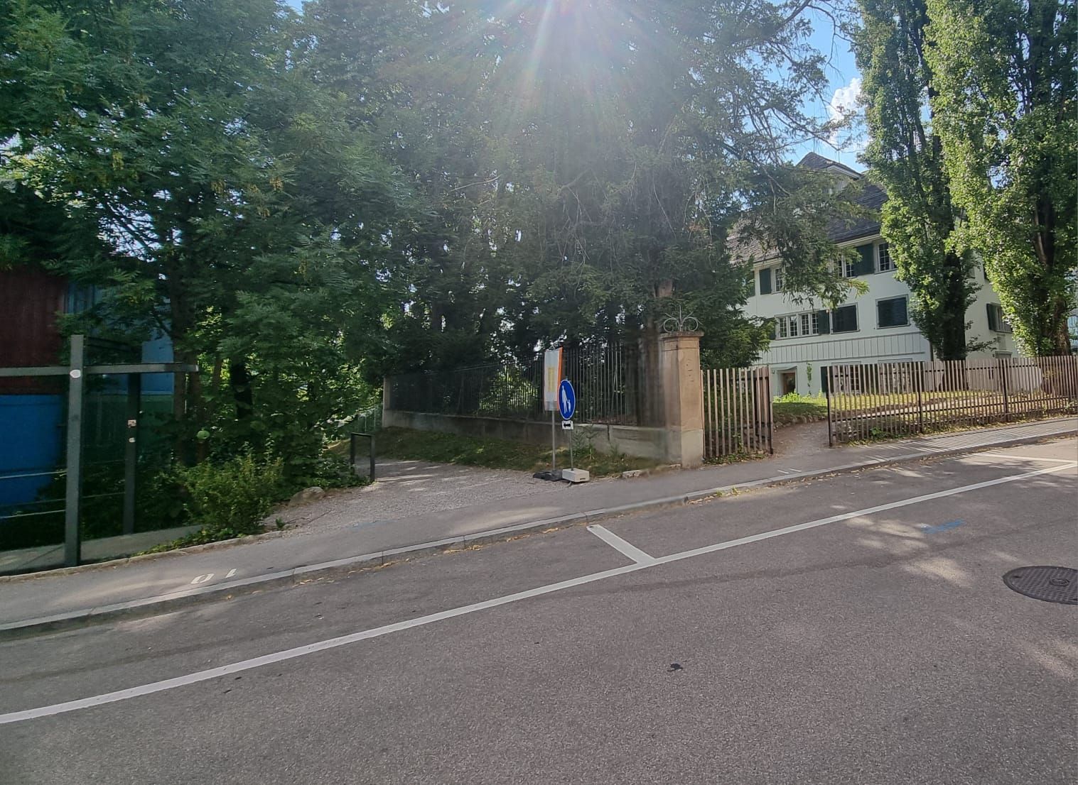 SOB Gebäude: Parkplätze mit zentraler Parkuhr einige Meter entfernt vom Gebäude. Die maximale Parkdauer beträgt zwei Stunden. Rechts im Bild erkennt man das Bodmerhaus. Durch das offene Eingangstor sieht man entfernt den barrierefreien Eingang.
