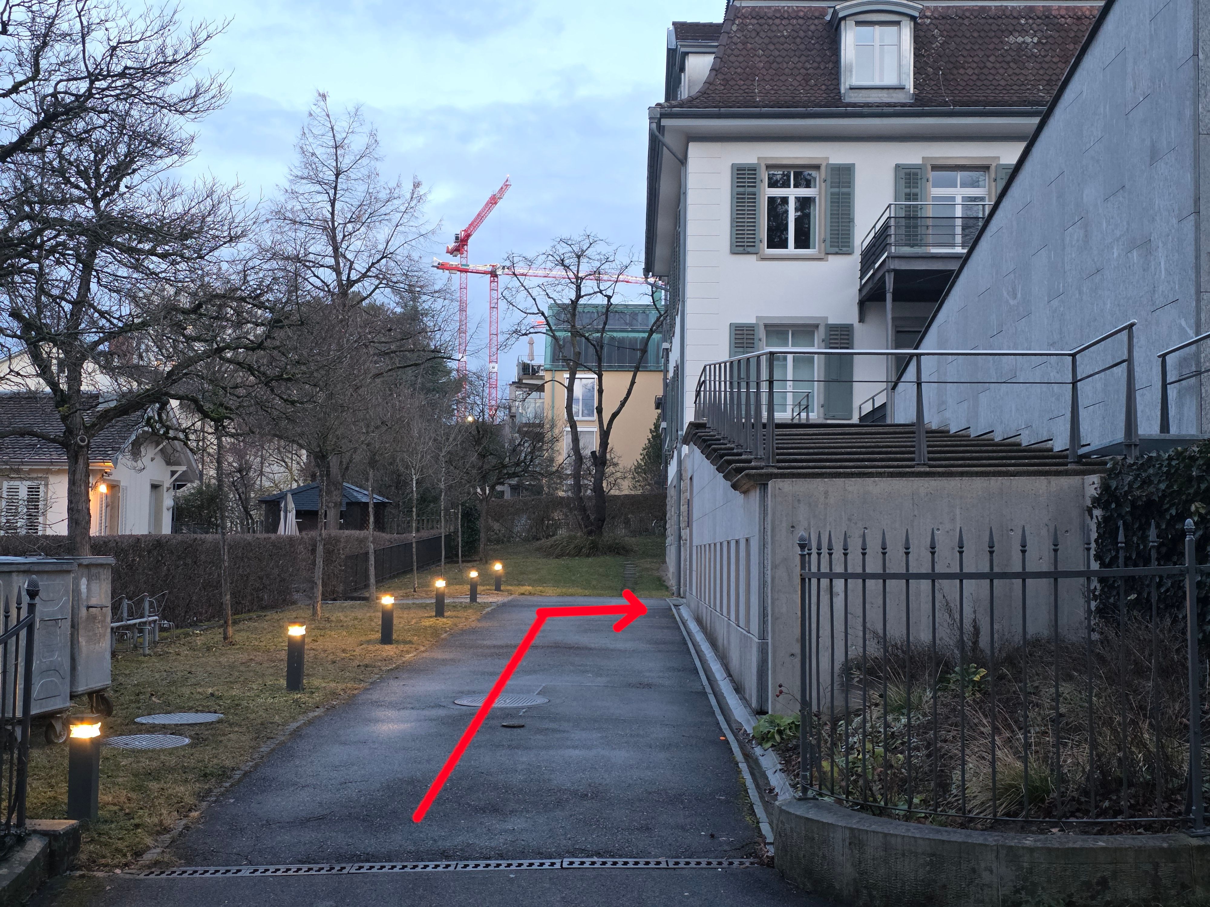 PET Gebäude: Der Weg zum stufenlosen Eingang ist mit einem roten Pfeil markiert.
3) Ab hier muss man geradeaus und dann nach rechts abbiegen.