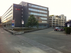 Gebäude AND: Links: Haupteingang ins Gebäude AND.
Rechts: Parkplätze.