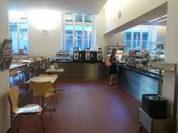 RAI-E, Cafeteria: Links die beiden Tische im Bild sind mit einem Rollstuhl-Signet versehen. Geradeaus befinden sich die Kaffee-Automaten, links davon die Besteckkästen. Rechts im Bild ist das Selbstbedienungsbuffet zu sehen.