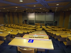 Hörsaal Y24-G-45: Sicht nach vorne.

Vorne im Bild ein mit Rollstuhl-Signet markierter Tisch und eine Reihe weiter vorne befindet sich der Tisch für die Begleitperson (roter Kreis und Beschriftung).